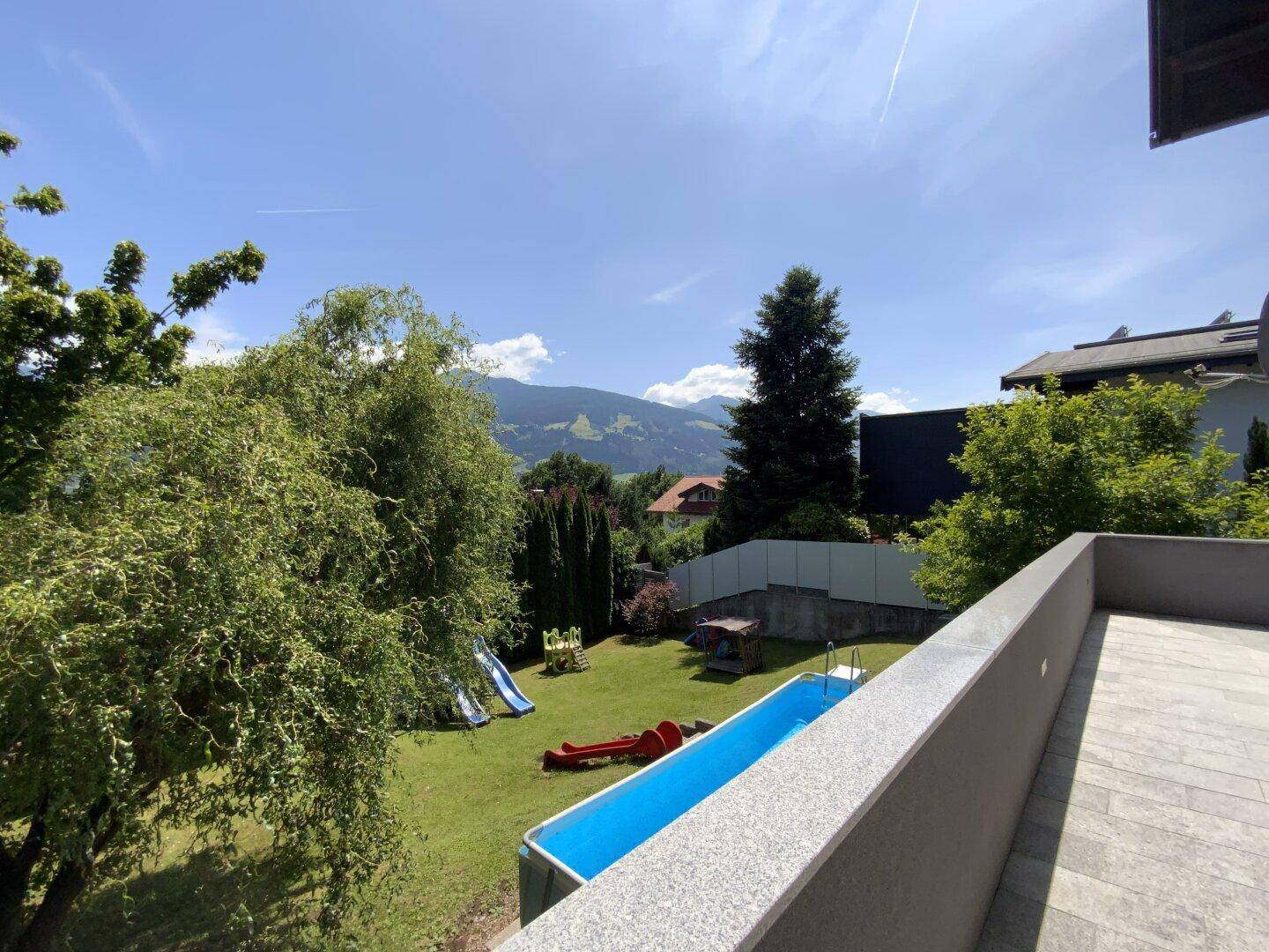 Balkon mit Blick auf den Garten, den Aufstellpool und den Kinderspielplatz.