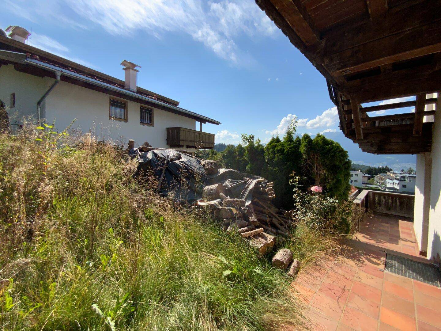 Außenterrasse mit Terrakottaboden und Blick auf die umliegende Landschaft und Berge.