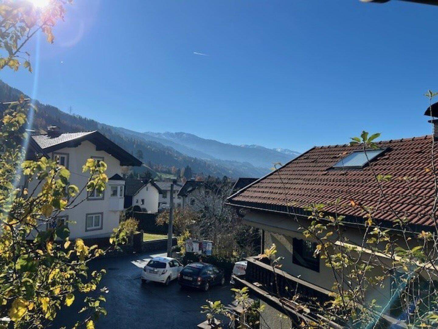 Weitblick über die Dächer der Nachbarschaft mit majestätischem Bergpanorama im Hintergrund.