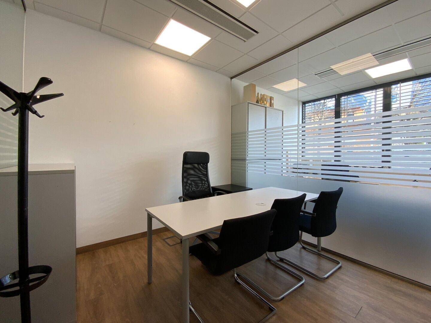 Büro mit Schreibtisch, Bürostuhl und Garderobenständer.
