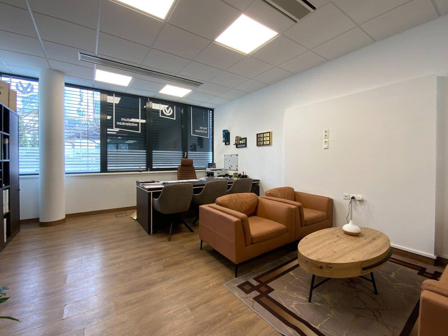 Geräumiges Büro mit Ledersesseln, Holztisch und Blick auf die Umgebung.