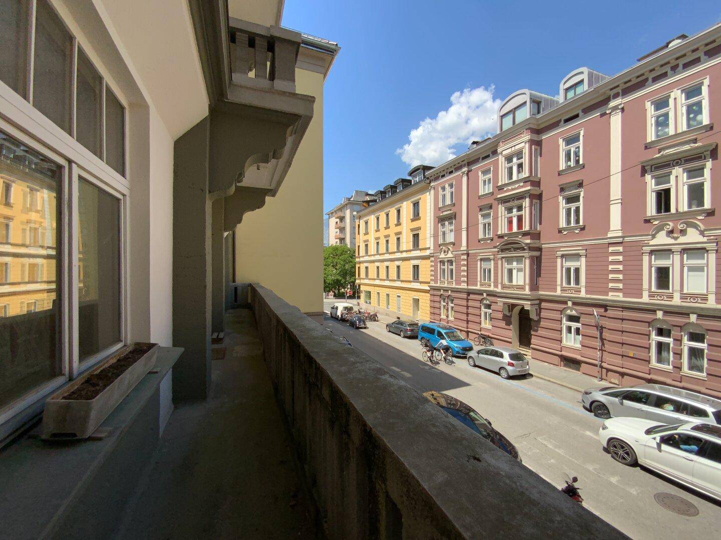 Balkon mit Blick auf die belebte Straße und die gegenüberliegenden Gebäude in der Stadt.