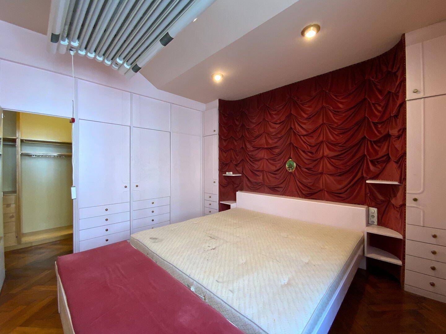 Schlafzimmer mit großem Bett, Einbauschränken und einer dekorativen Wandgestaltung, stilvoll und funktional.