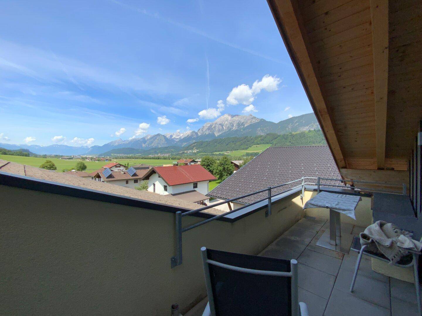 Sonniger Balkon mit atemberaubendem Bergblick und Sitzgelegenheiten für entspannte Momente.