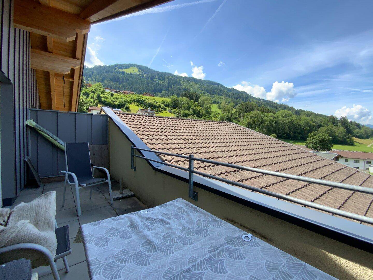Geräumiger Balkon mit Sitzgelegenheiten und weitem Blick auf die umliegende Hügellandschaft.