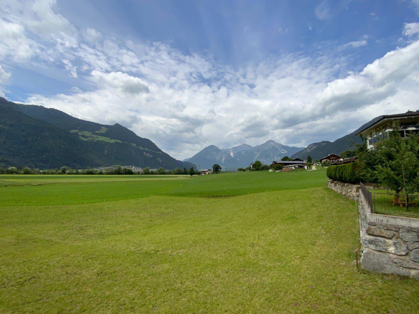 Weitläufige grüne Wiesen und majestätische Berge prägen die idyllische Landschaft rund um das Anwesen.
