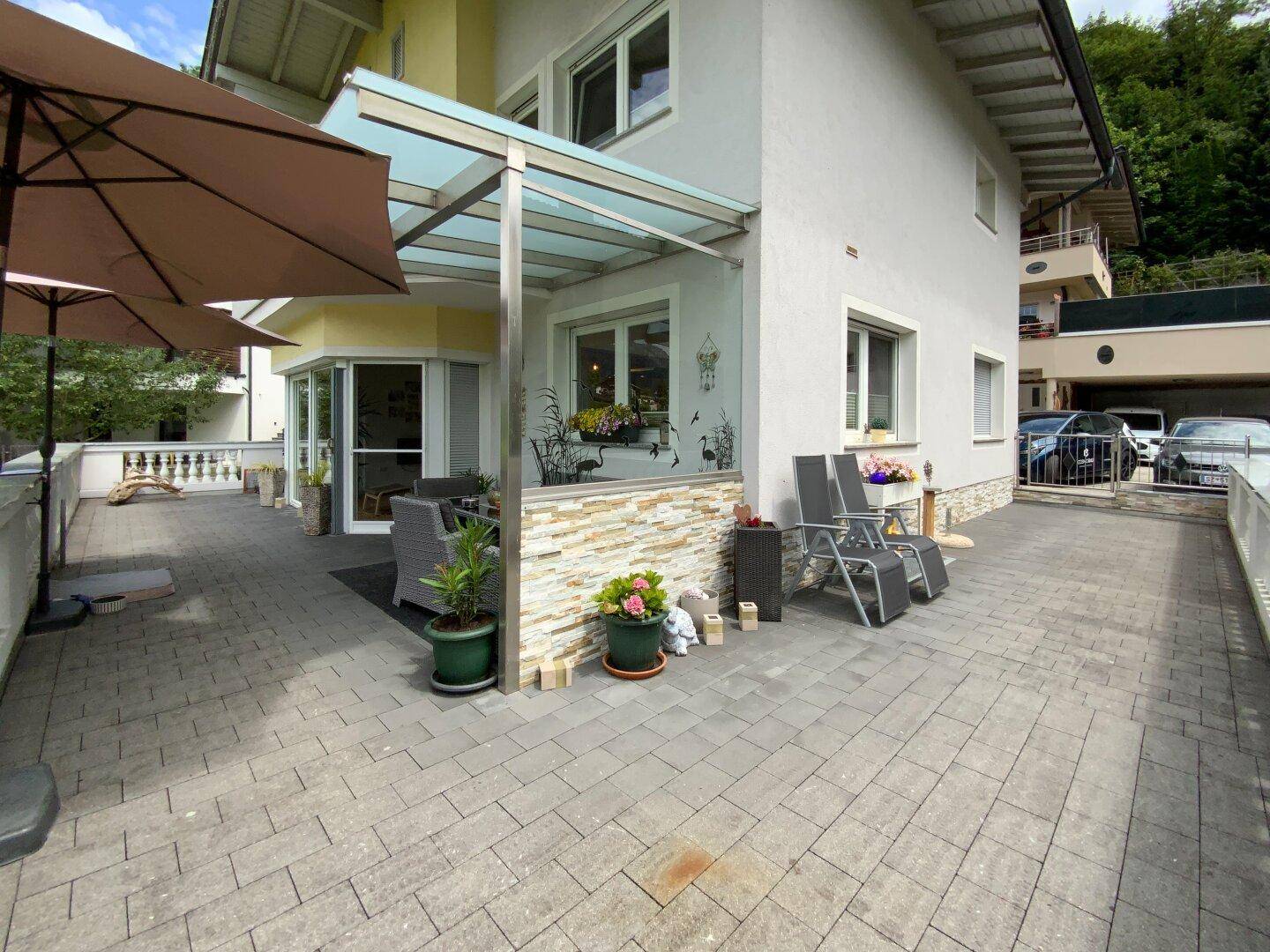 Geräumige gepflasterte Terrasse mit Sitzgelegenheiten und Zugang zum Haus, ideal für Entspannung im Freien.