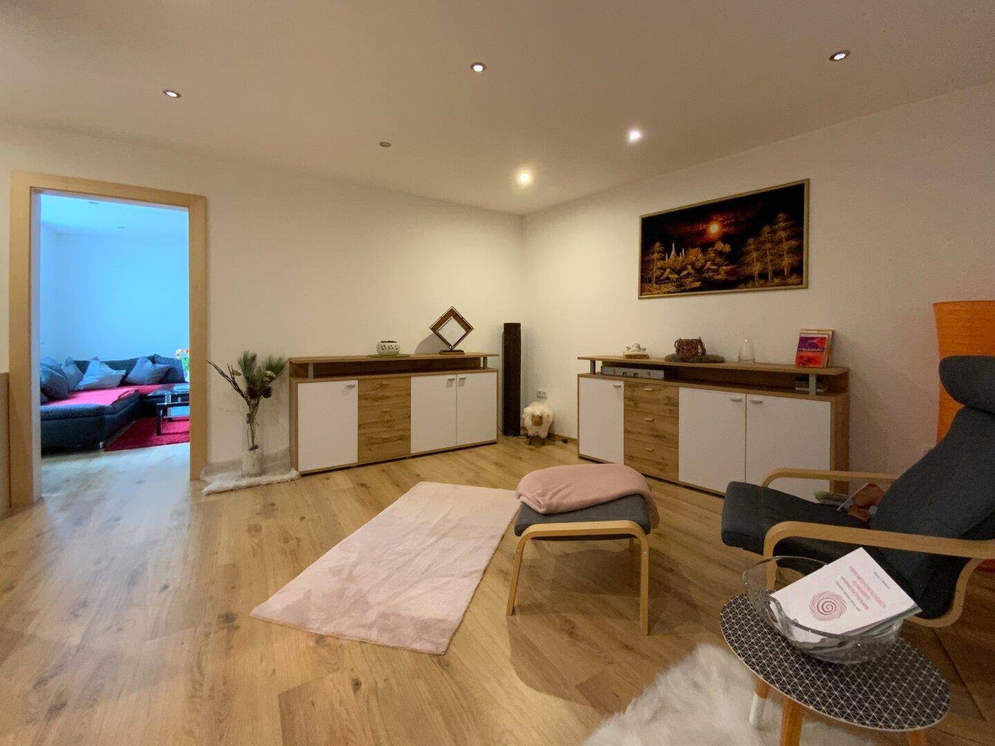 Gemütlicher Wohnbereich mit Holzboden und modernen Sideboards, ideal für Entspannung und Dekoration.