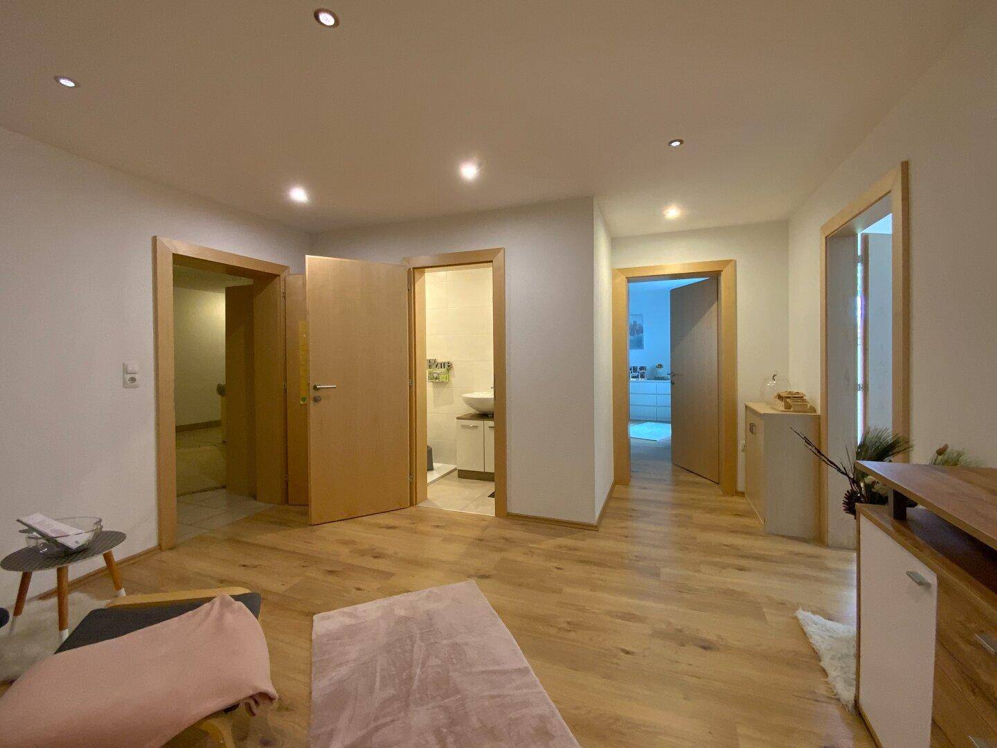 Heller Flur mit Holzboden und mehreren Türen, die zu verschiedenen Räumen des Hauses führen.