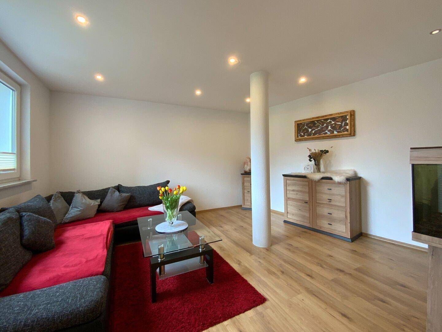 Geräumiges Wohnzimmer mit großem Ecksofa, Couchtisch und hellem Holzboden, einladend und komfortabel.