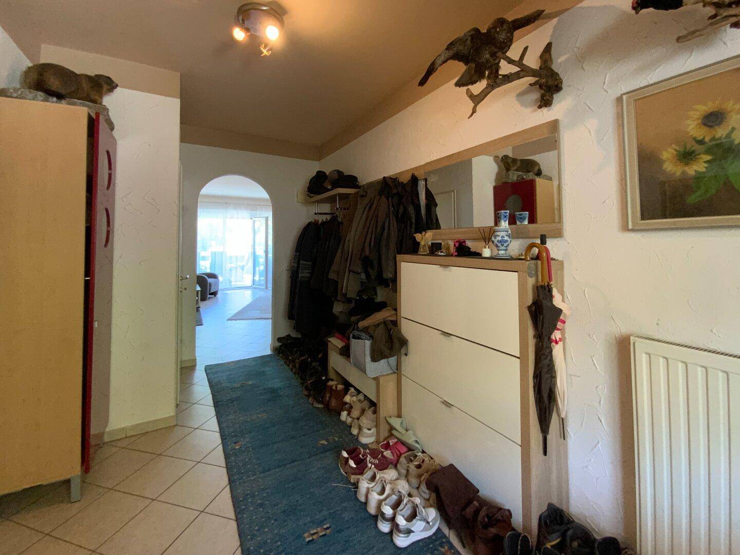 Geräumiger Flur mit Schuhschrank, großem Spiegel und traditionellen Dekorationselementen.