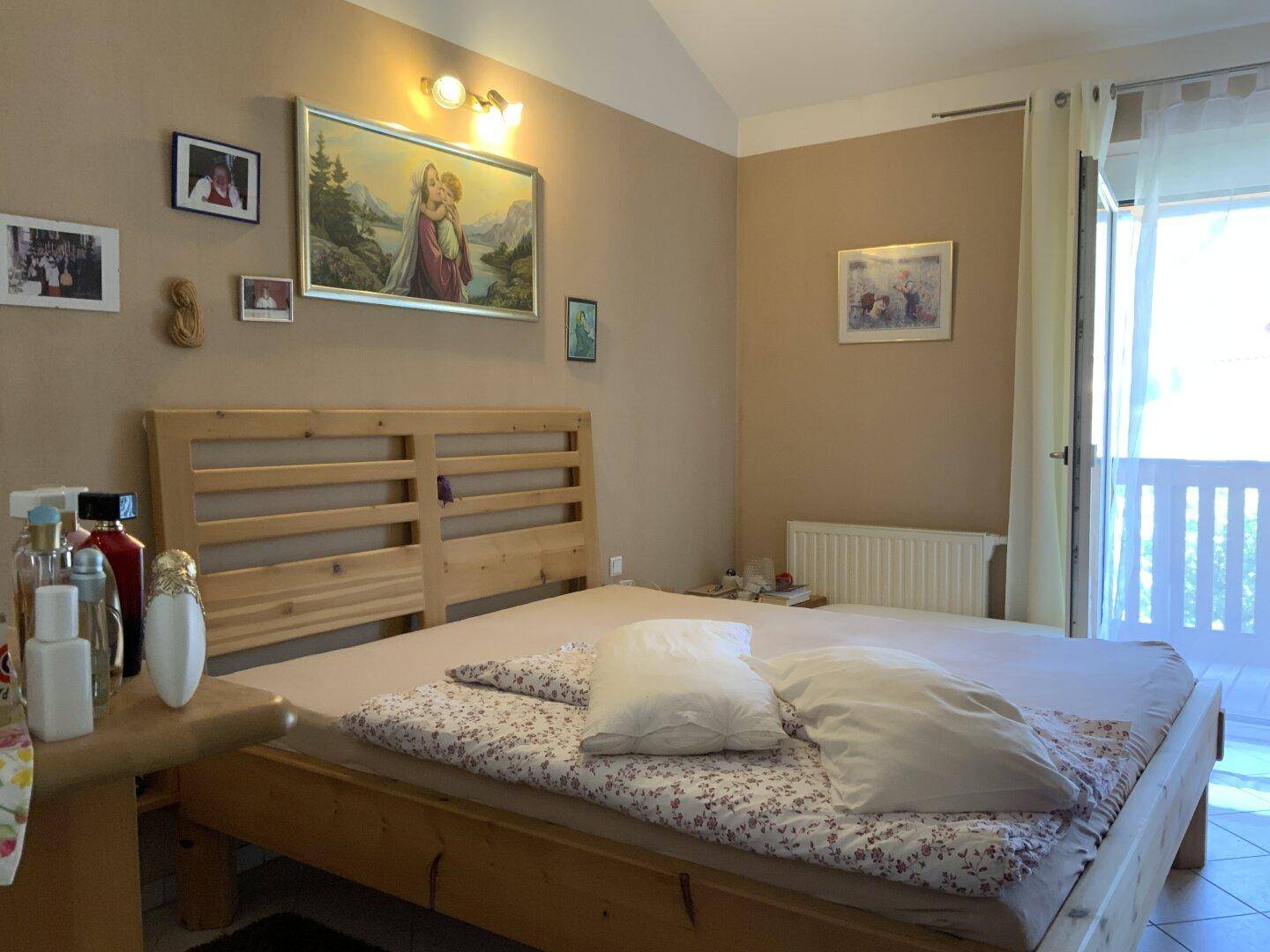 Geräumiges Schlafzimmer mit Doppelbett aus Holz und direktem Zugang zu einem Balkon.