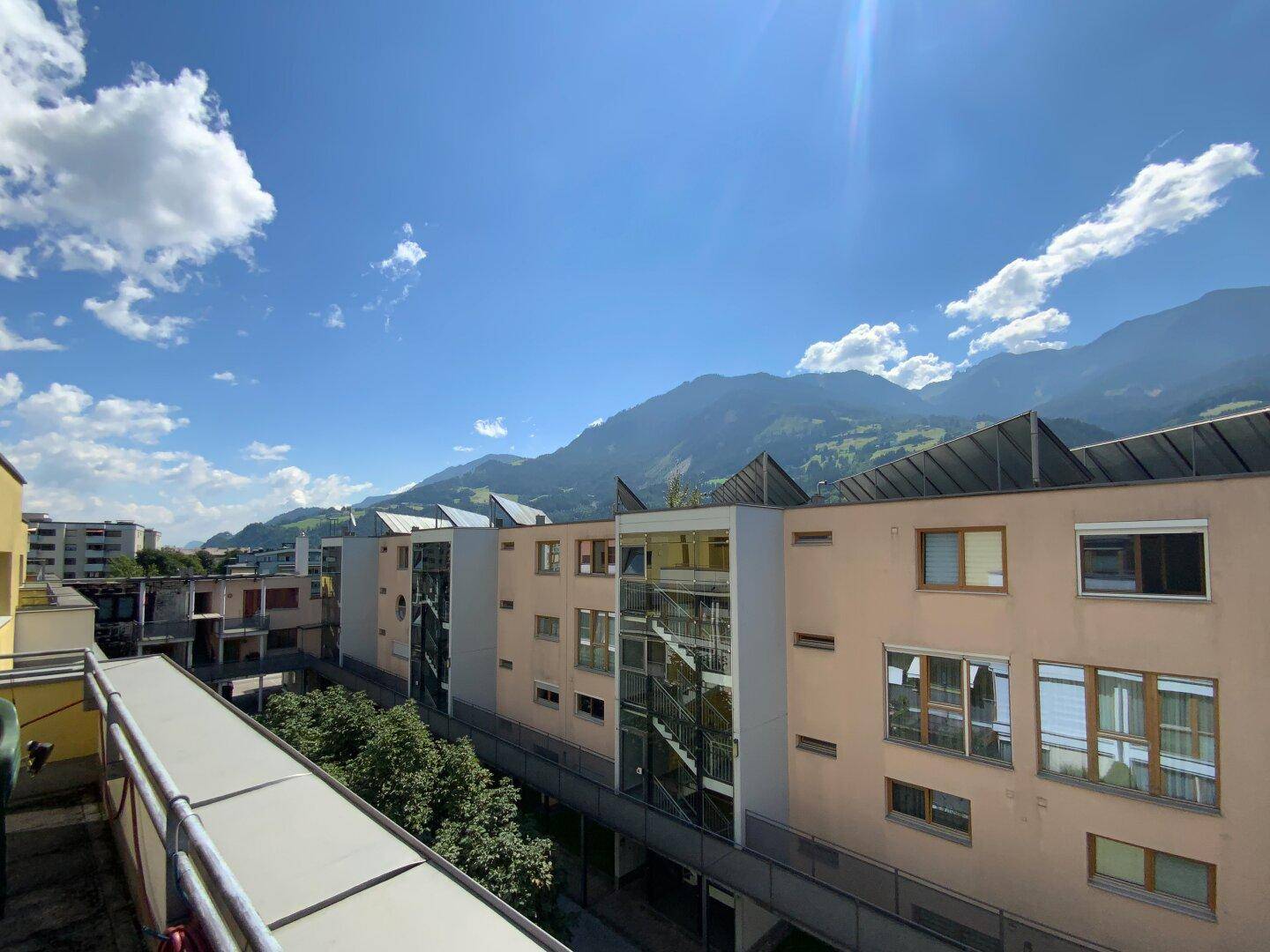 Weiter Blick über die Dächer der Stadt und die beeindruckende Bergkulisse.