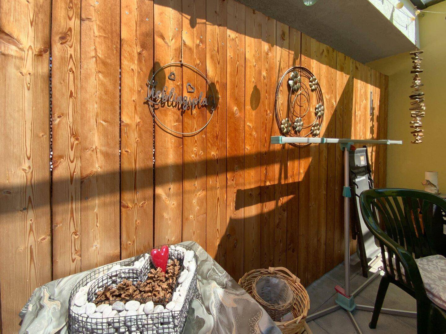 Detailansicht der Holzverkleidung auf der Terrasse mit dekorativen Elementen und viel Sonnenlicht.