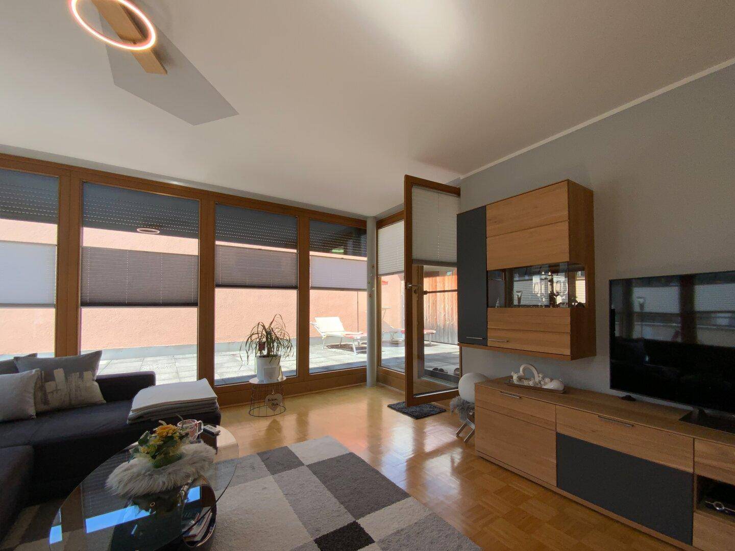 Wohnzimmer mit direktem Zugang zur großzügigen Terrasse und viel Tageslicht.