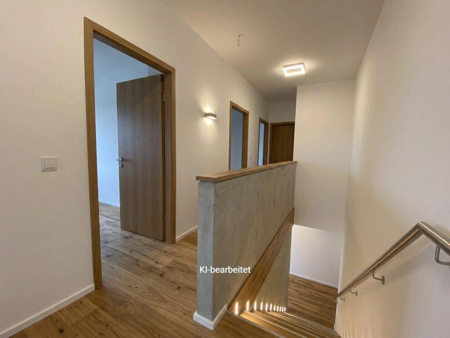 Heller Flur mit Holzboden, weißen Wänden und Zugang zu weiteren Räumen im modernen Stil.