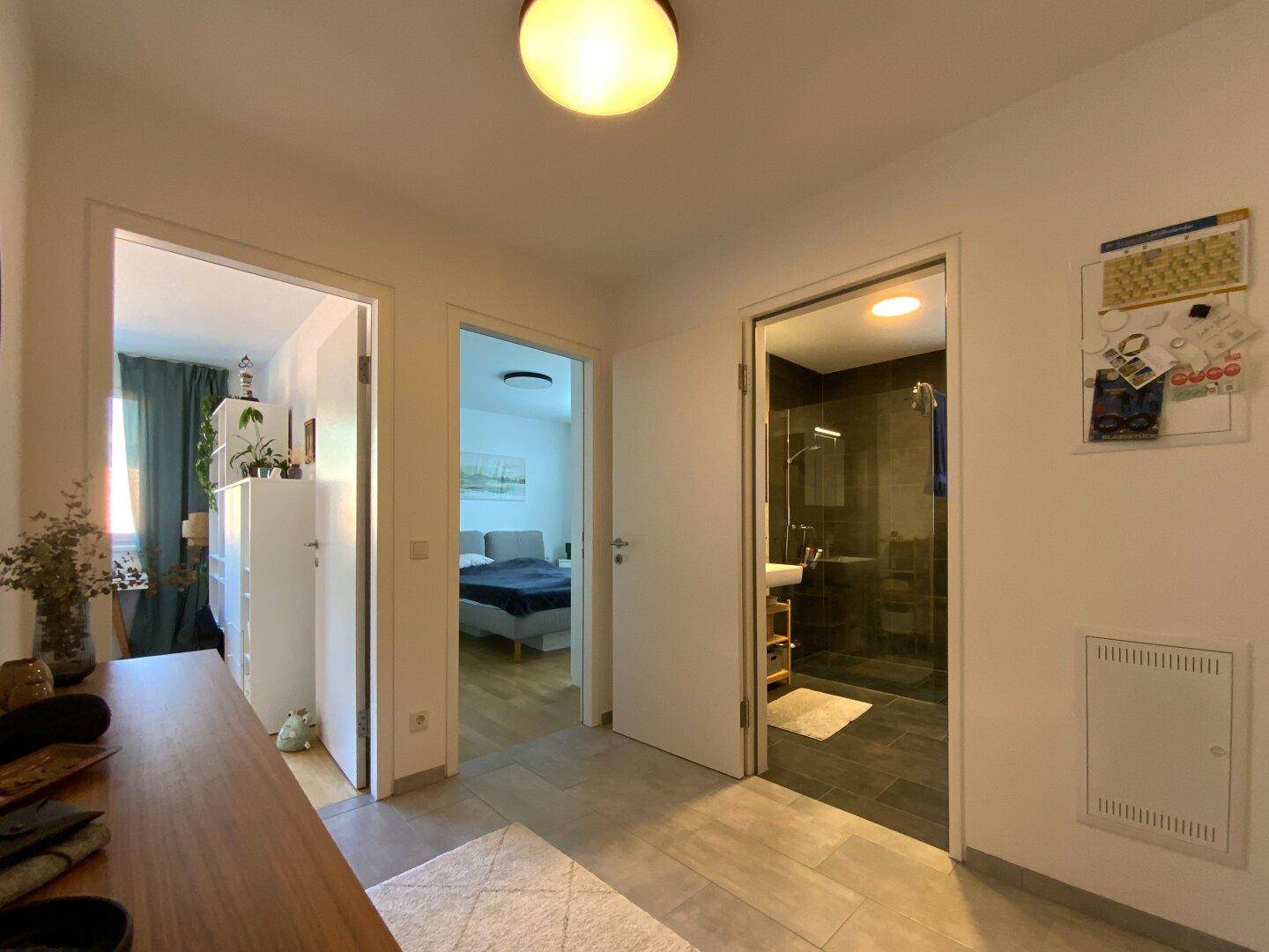 Flur mit Zugang zu Schlafzimmer und Badezimmer, ausgestattet mit modernen Türen.