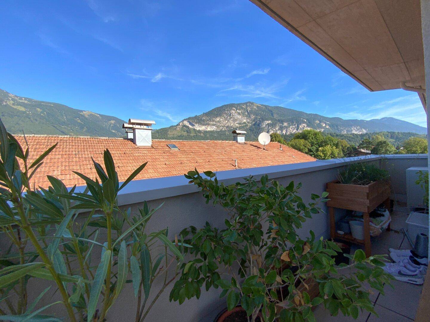 Sonniger Terrassenbereich mit weitem Blick auf die Berge und die umliegende Natur.