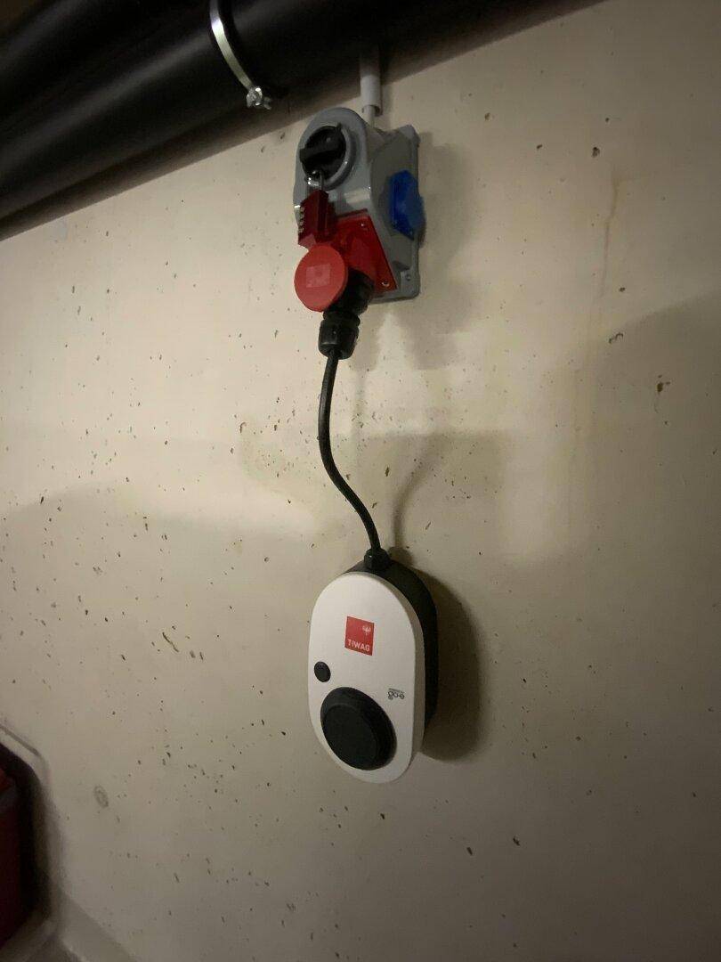 Ladestation für Elektrofahrzeuge an der Wand einer Tiefgarage installiert.