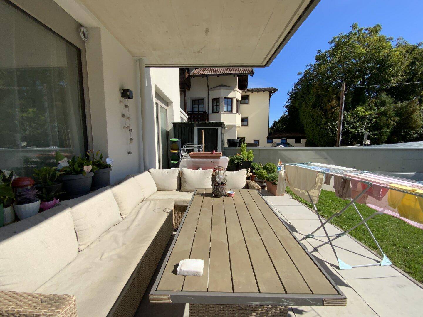 Gemütliche Terrasse mit Lounge-Möbeln, Sonnenschutz und Blick ins Grüne.