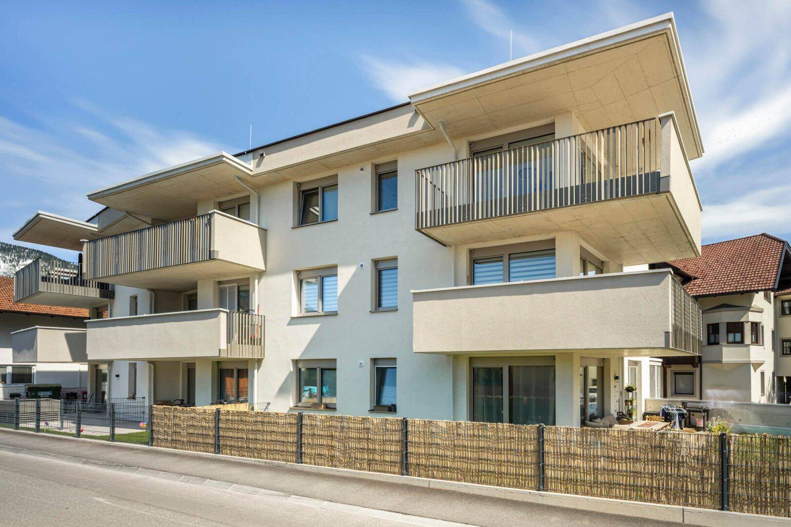 Attraktives Mehrfamilienhaus mit mehreren Balkonen und moderner Architektur.