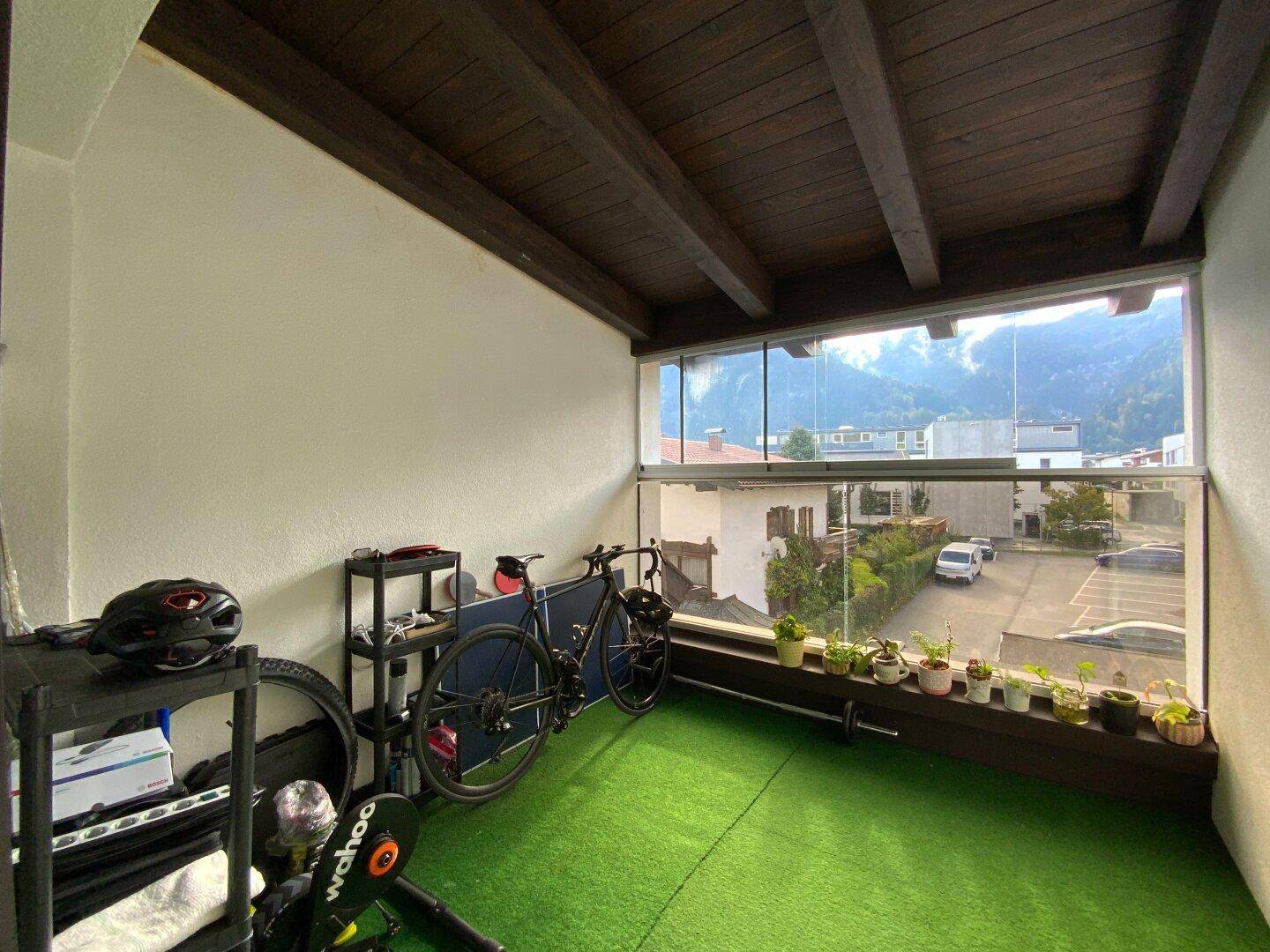 Verglaste Loggia, genutzt als Fitnessbereich, mit Blick auf die umliegende Berglandschaft.
