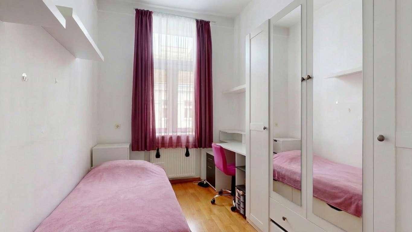 Helles Kinderzimmer mit Einzelbett, Schreibtisch und Kleiderschrank mit Spiegeltüren.