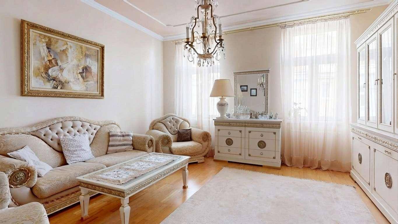 Geräumiges Wohnzimmer mit bequemen Sofas, klassischem Dekor und großen Fenstern.
