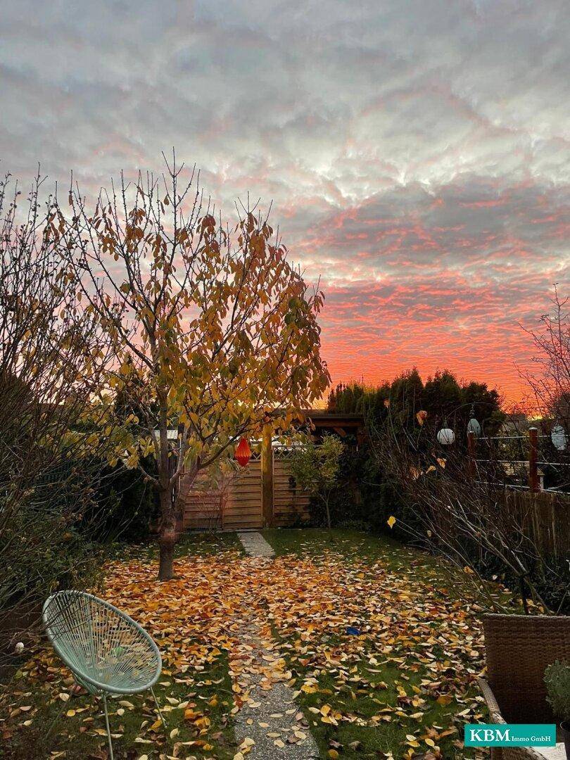 Herbstlicher Garten bei Sonnenuntergang mit bunten Blättern und gemütlicher Atmosphäre.