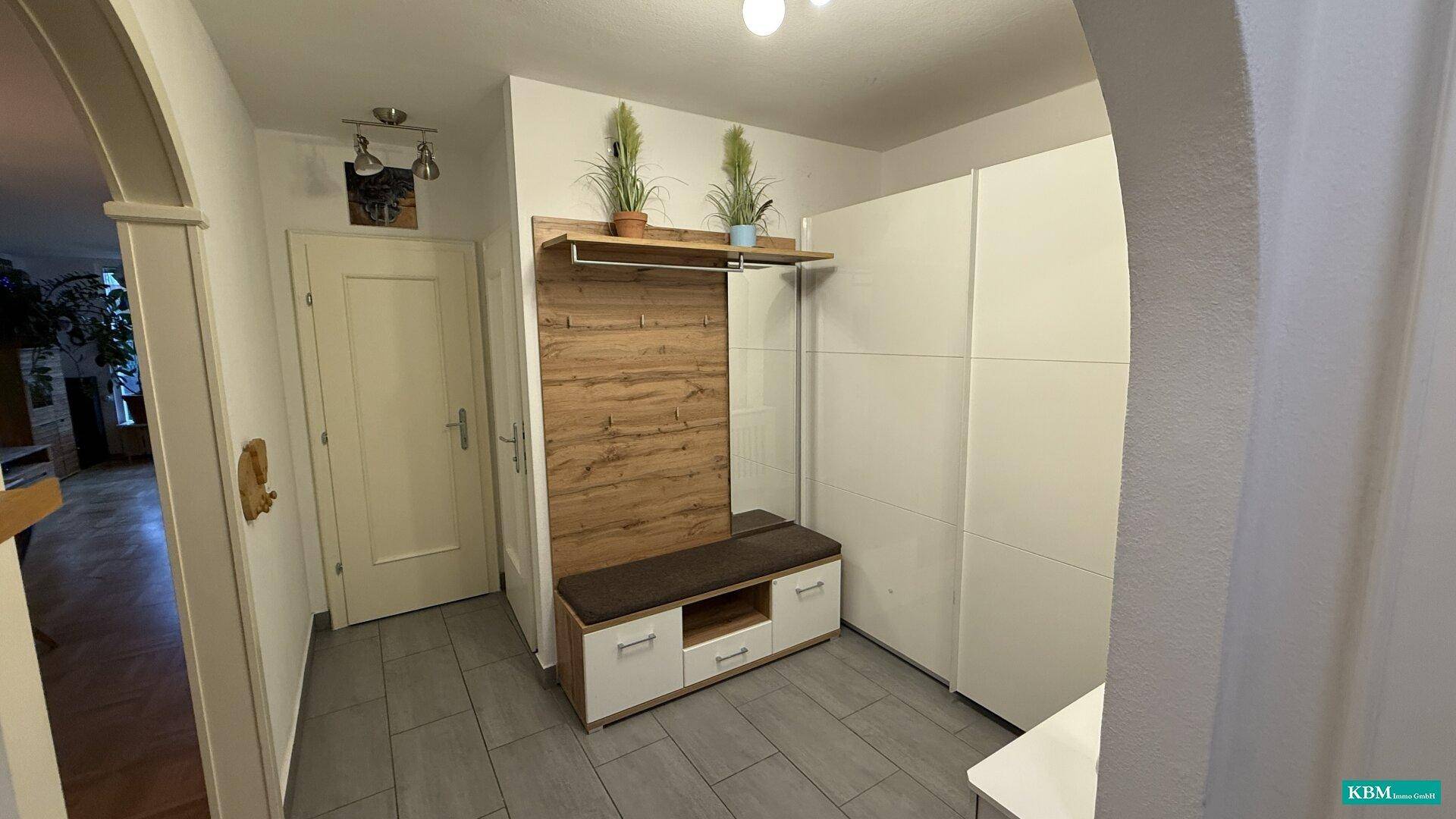 Heller Flur mit Garderobe, Einbauschrank und Fliesenboden im Eingangsbereich.