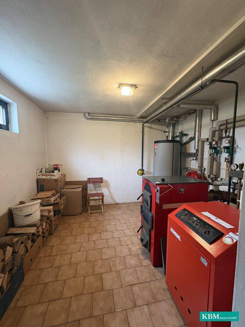 Heizungsraum im Keller mit modernen Heizkesseln und Brennstofflagerung.