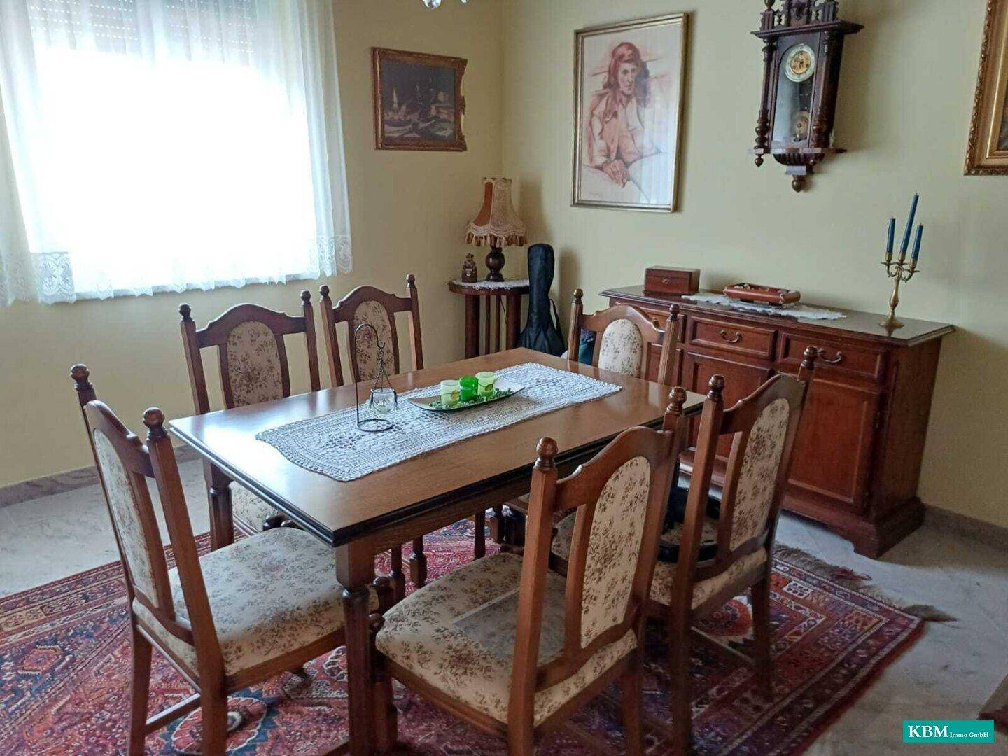 Klassischer Essbereich mit Holztisch, gepolsterten Stühlen und einem traditionellen Orientteppich.