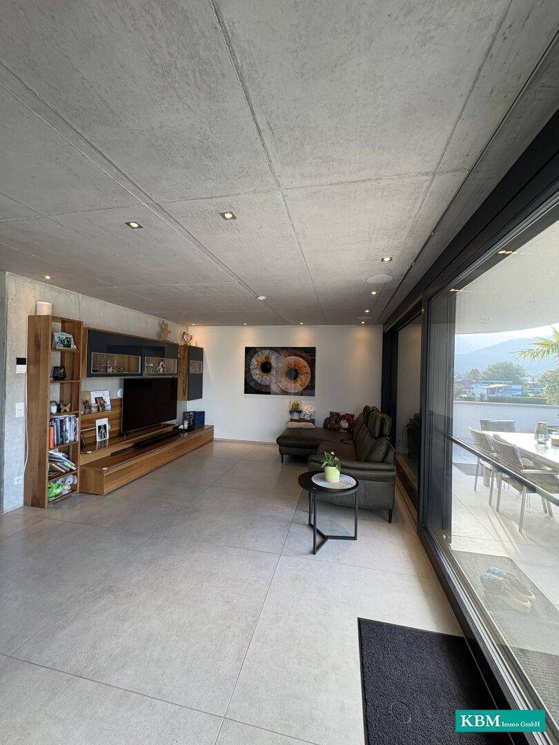 Geräumiges Wohnzimmer mit moderner Einrichtung, großem TV-Möbel und Zugang zur Terrasse.