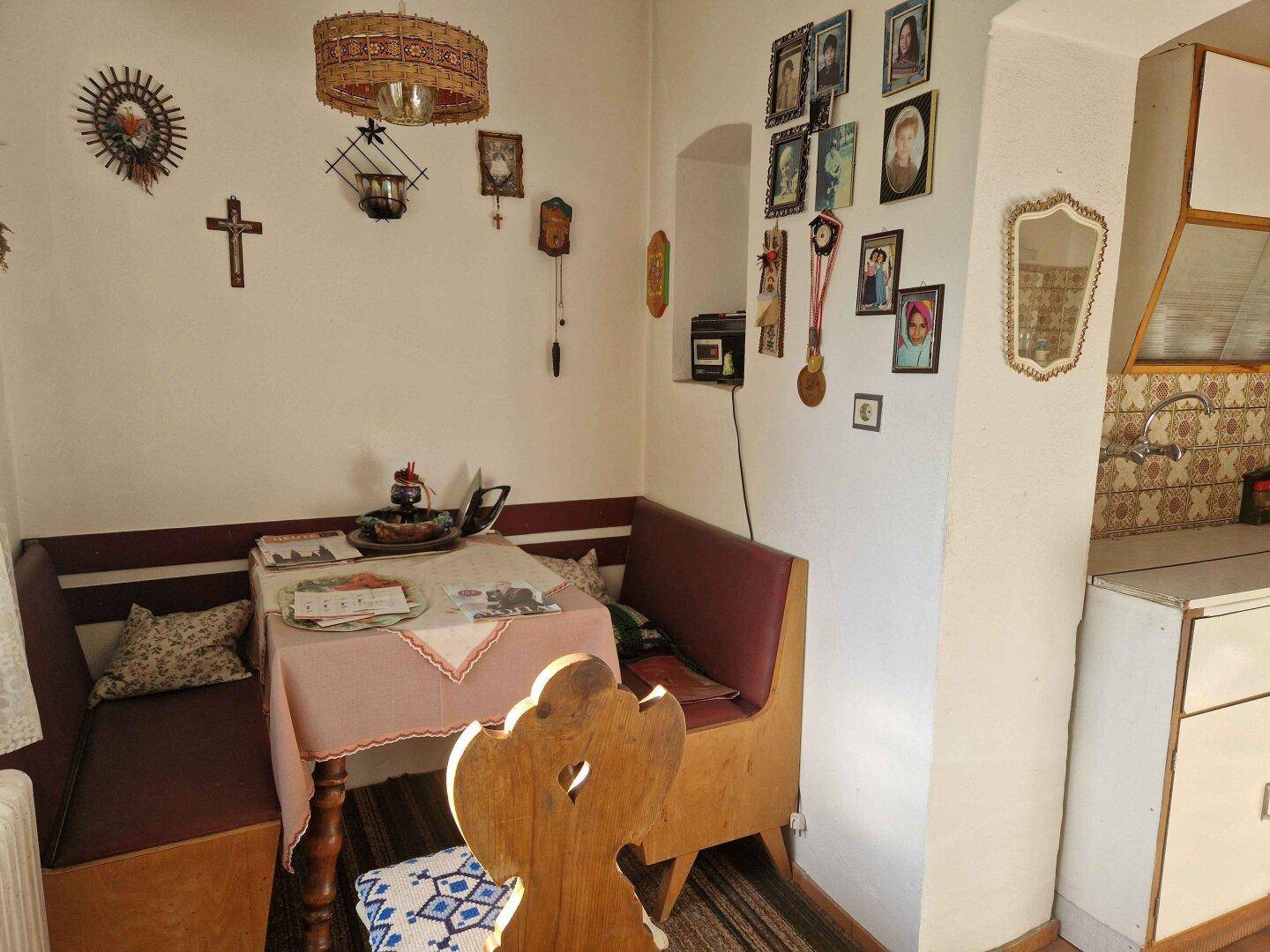 Kleiner Essbereich in der Küche mit Eckbank, Holztisch und traditioneller Dekoration, ideal für Mahlzeiten.