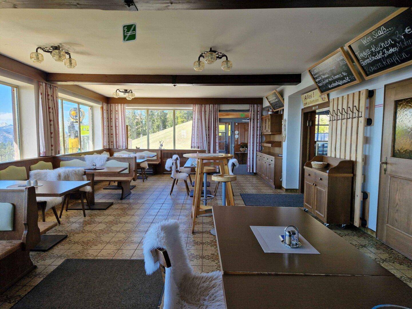 Geräumiger Speisesaal mit Holzelementen, großen Fenstern und traditioneller Einrichtung.