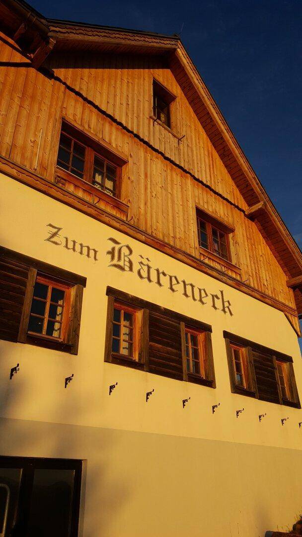 Detailansicht der Fassade mit Holzelementen, Fenstern und dem Schriftzug "Zum Bäreneck".