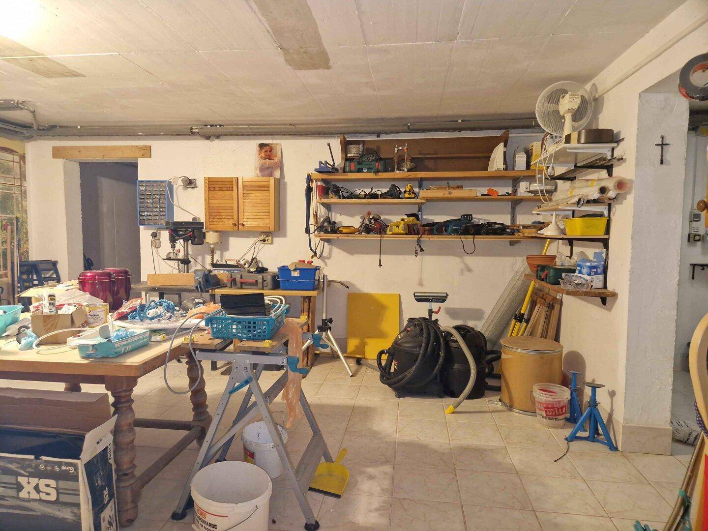 Kellerwerkstatt mit Regalen, Werkzeugen und viel Platz für handwerkliche Tätigkeiten.