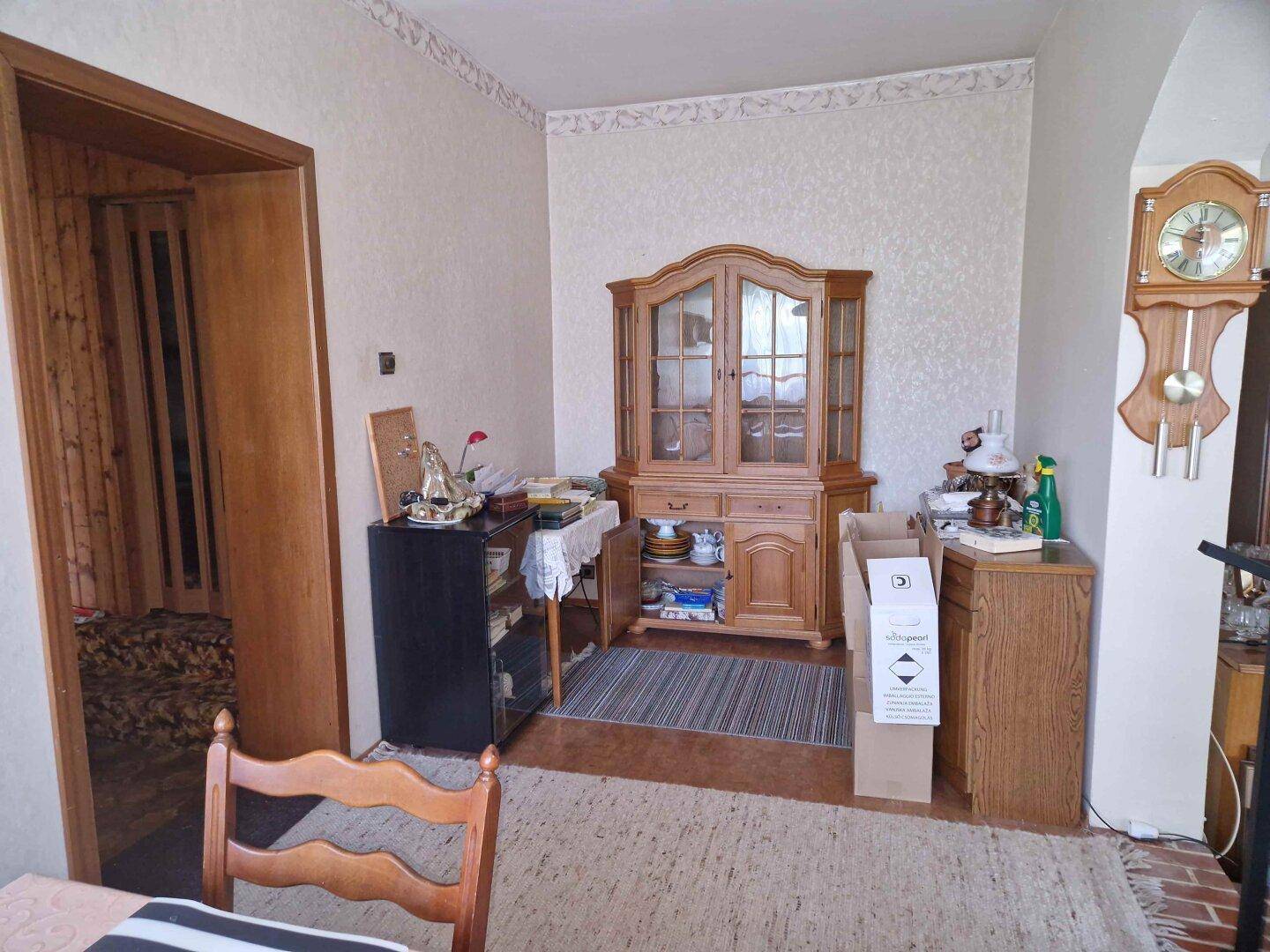 Essbereich oder Flur mit traditionellem Holzschrank und gemusterter Tapete, bietet zusätzlichen Stauraum.