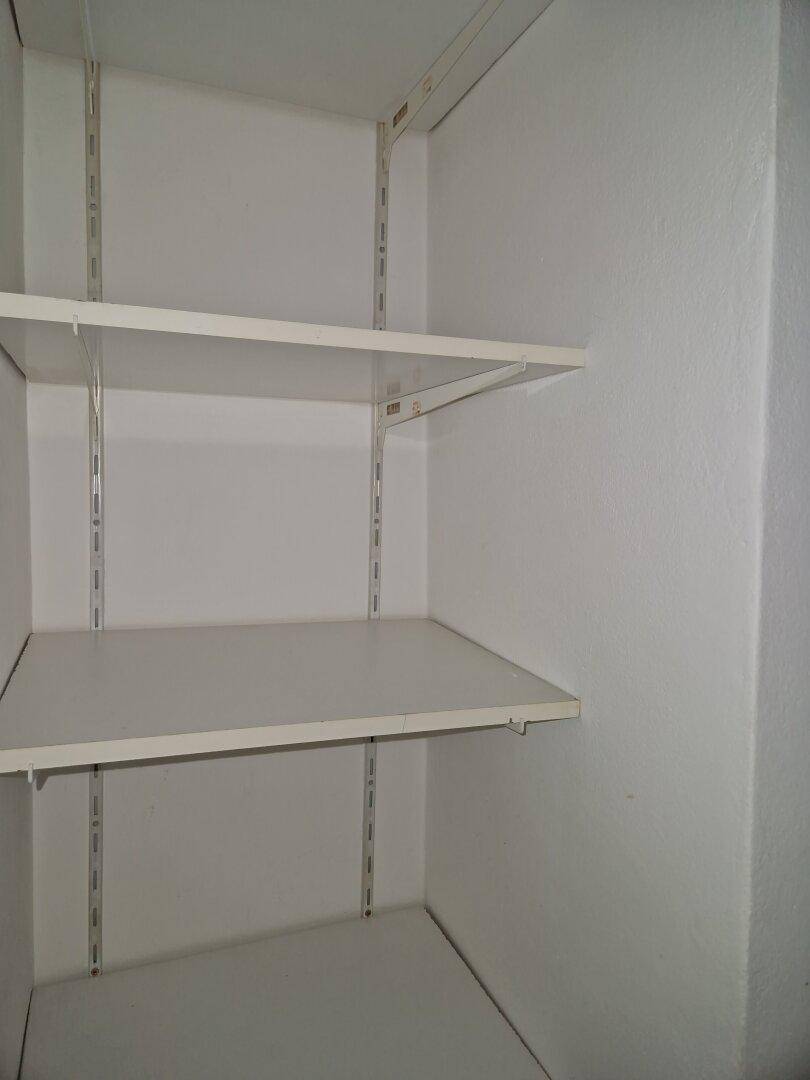 Praktischer Abstellraum mit weißen Regalböden für zusätzlichen Stauraum im Haushalt.