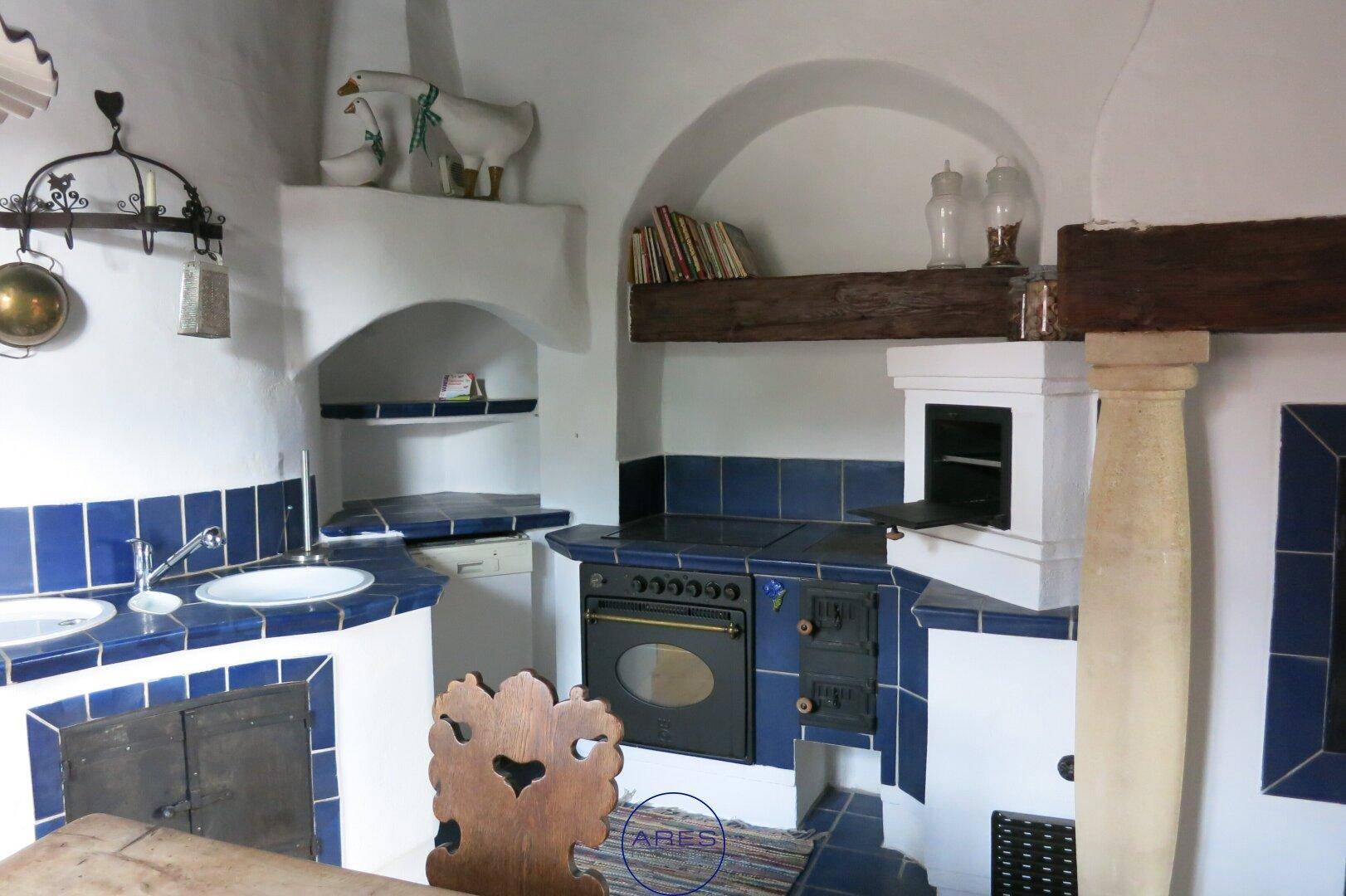 Einzigartige Küche im Landhausstil mit blauen Fliesen, integriertem Ofen und rustikalen Holzelementen.