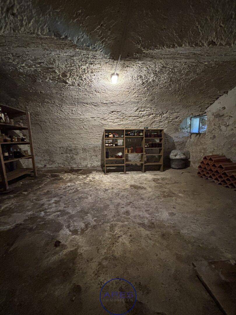 Rustikaler Weinkeller mit Regalen und Flaschenlagerung, ideal für Weinliebhaber.
