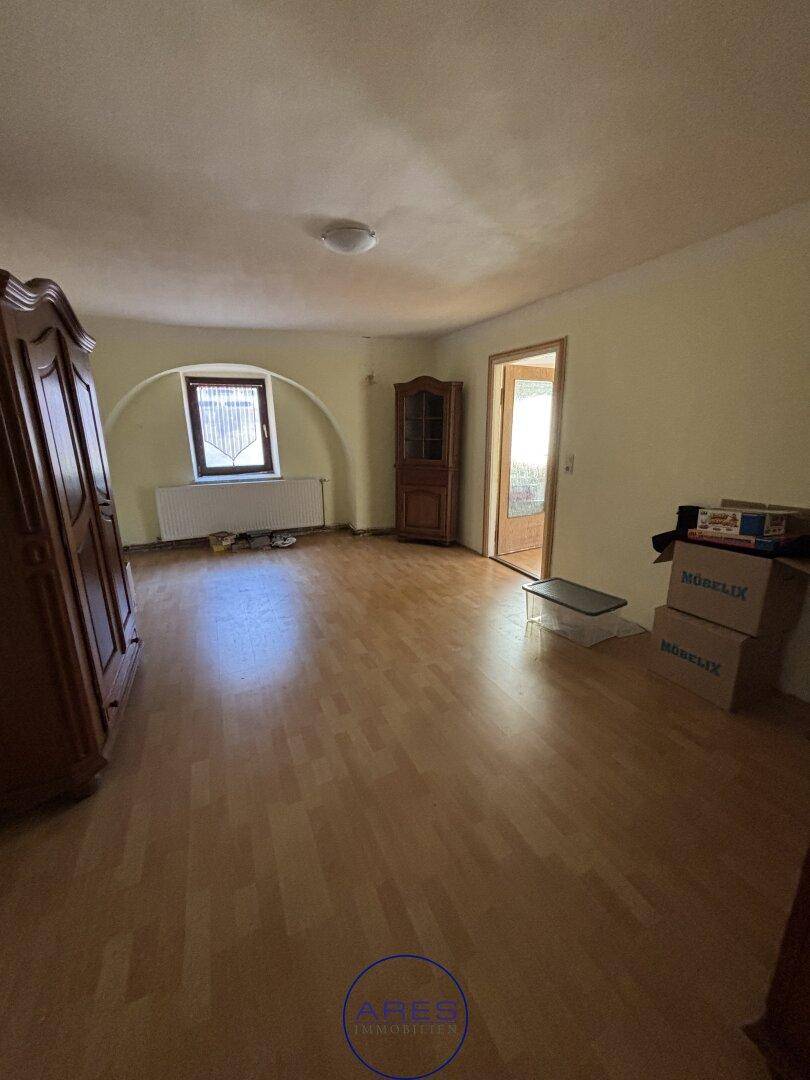Geräumiger Raum mit Laminatboden, einem Fenster und traditionellen Holzschränken.