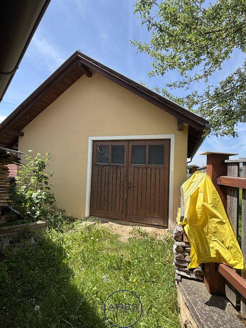 Rustikale Garage oder Schuppen mit doppelten Holztüren und gelber Fassade.