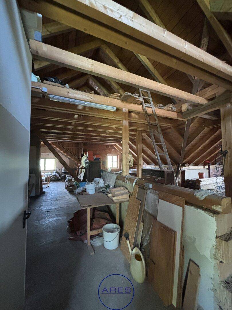 Geräumiger Dachboden mit sichtbaren Holzbalken und Baumaterialien, bietet viel Ausbaupotenzial.
