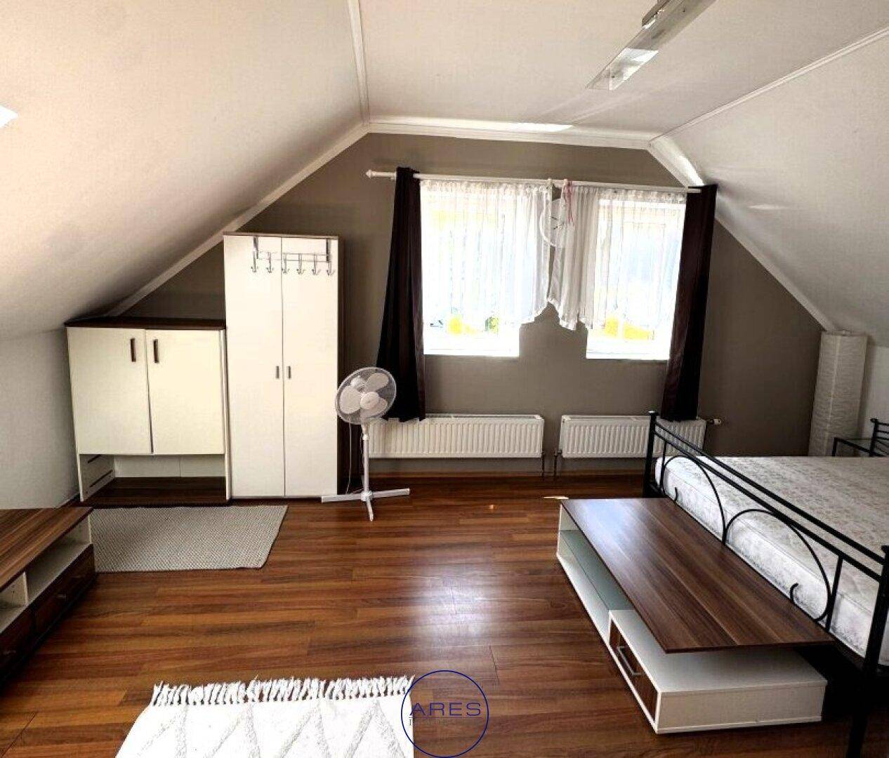 Geräumiges Schlafzimmer im Dachgeschoss mit Laminatboden und Dachschrägen.