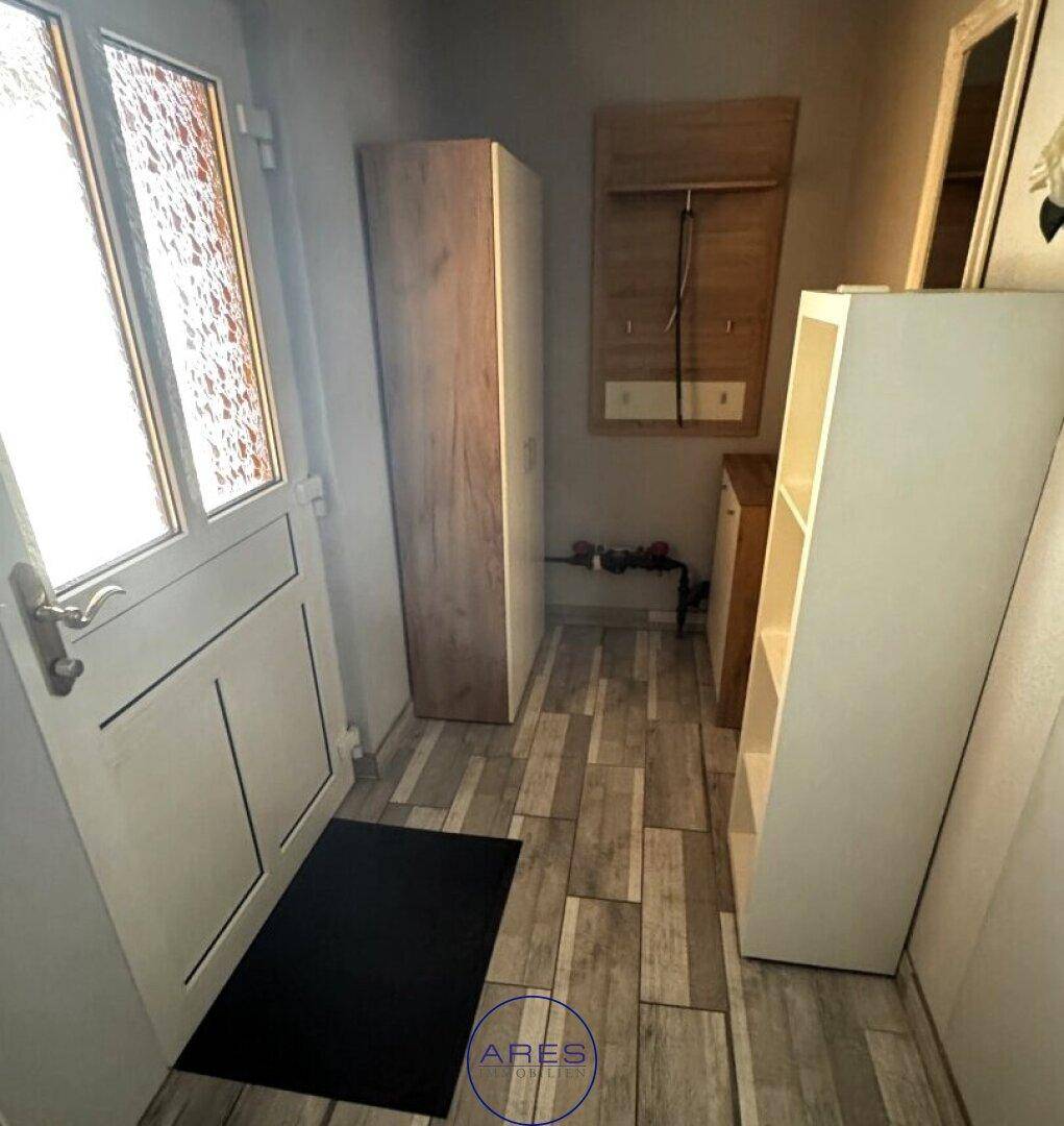 Eingangsbereich mit Garderobe, Schuhschränken und hellem Laminatboden.