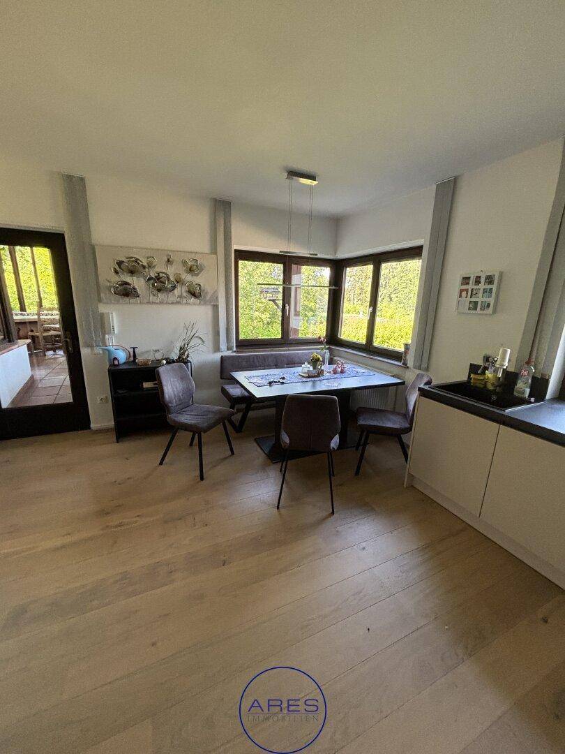 Heller Essbereich in der Küche mit Eckbank und großzügigen Fenstern mit Blick ins Grüne.