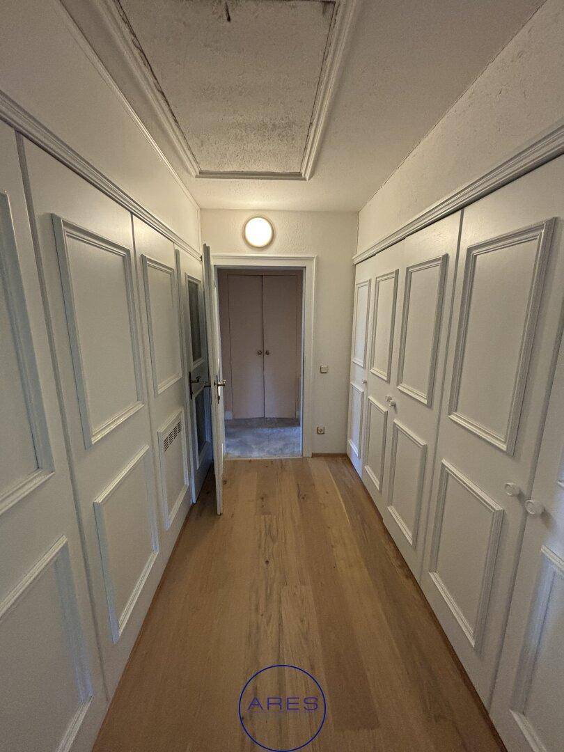 Heller Flur mit Holzboden und eleganten Einbauschränken.