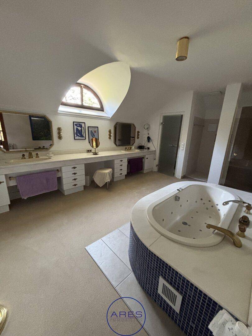Luxuriöses Badezimmer mit Whirlpool, Doppelwaschbecken und Dachfenster.