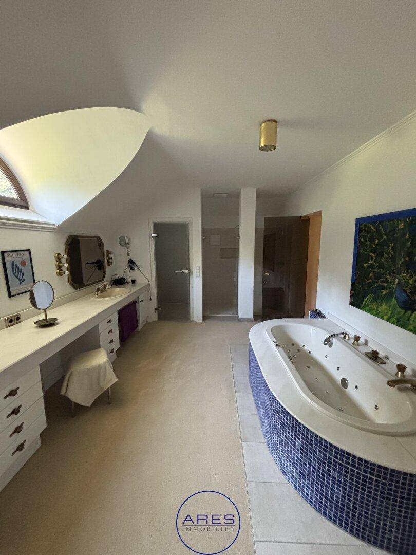Großes Badezimmer mit Whirlpool, Doppelwaschbecken und Dachfenster.